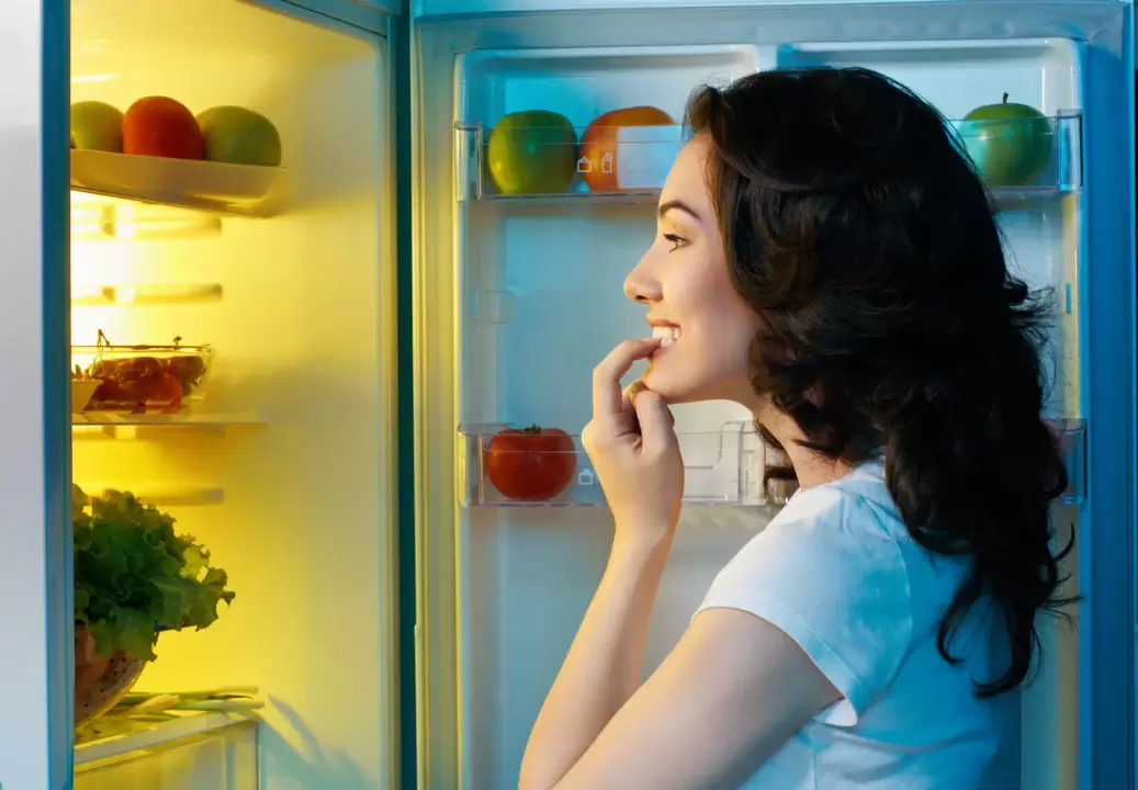 fille regarde dans le réfrigérateur pendant une perte de poids rapide