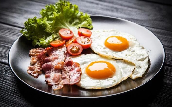 Deux œufs à deux bouils avec du bacon